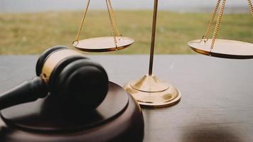Justice and law concept.Male judge in a courtroom with the gavel, working with, computer and docking keyboard, eyeglasses, on table in morning light video