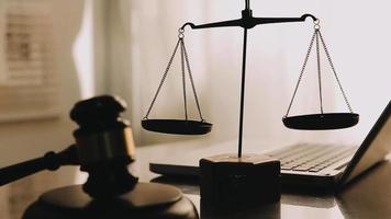 Justice and law concept.Male judge in a courtroom with the gavel, working with, computer and docking keyboard, eyeglasses, on table in morning light video