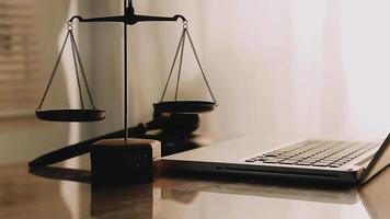 Justice and law concept.Male judge in a courtroom with the gavel, working with, computer and docking keyboard, eyeglasses, on table in morning light video