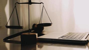 Justice and law concept.Male judge in a courtroom with the gavel, working with, computer and docking keyboard, eyeglasses, on table in morning light video