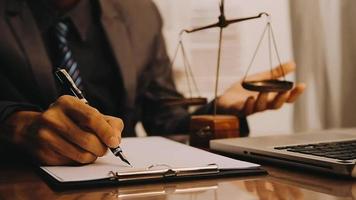 Justice and law concept.Male judge in a courtroom with the gavel, working with, computer and docking keyboard, eyeglasses, on table in morning light video
