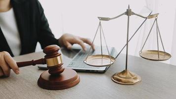 Justice and law concept.Male judge in a courtroom with the gavel, working with, computer and docking keyboard, eyeglasses, on table in morning light video