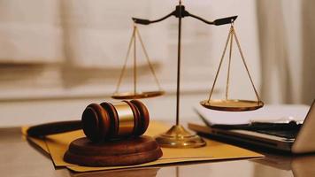 Justice and law concept.Male judge in a courtroom with the gavel, working with, computer and docking keyboard, eyeglasses, on table in morning light video