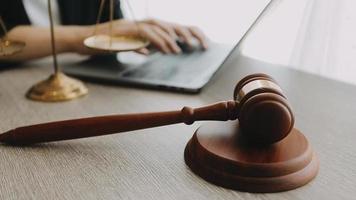 Justice and law concept.Male judge in a courtroom with the gavel, working with, computer and docking keyboard, eyeglasses, on table in morning light video