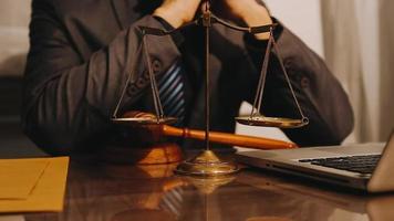 Justice and law concept.Male judge in a courtroom with the gavel, working with, computer and docking keyboard, eyeglasses, on table in morning light video