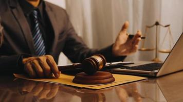 Justice and law concept.Male judge in a courtroom with the gavel, working with, computer and docking keyboard, eyeglasses, on table in morning light video