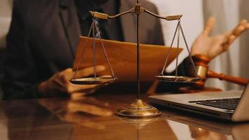 Justice and law concept.Male judge in a courtroom with the gavel, working with, computer and docking keyboard, eyeglasses, on table in morning light video