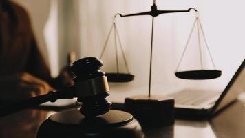 Justice and law concept.Male judge in a courtroom with the gavel, working with, computer and docking keyboard, eyeglasses, on table in morning light video