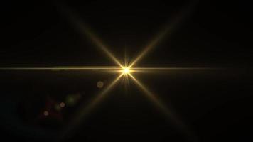 The bright light of the rays of a golden star in motion on black video