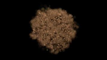 Explosive effect scattering of fragments of brown particles on a black background video