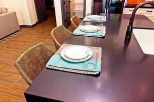 Place Settings And Counter Stools At Kitchen Island photo