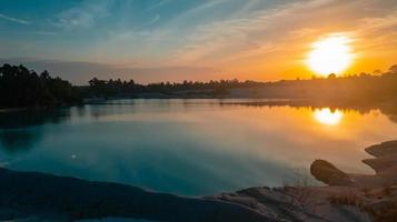 A beautiful sunset in a blue lake. Belitung Kaolin Lake, in Belitung Island photo