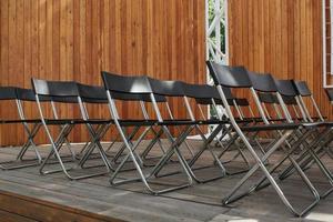 Empty plastic black chairs auditorium conference seminar room, office meeting hall for presentation, convention, lecture. Business corporate congress, seminar, education concept. Communication idea photo