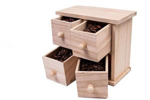 caja de madera con celdas llenas de granos de café. Granos de café dispersos uno al lado del otro aislado sobre fondo blanco. foto