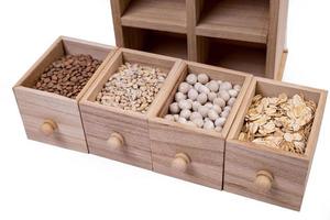 Pattern of raw cereals, beans and seeds, top view texture, mix of groats in square wooden box. Small wooden box with cells with beans lentils oatmeal seeds isolated on white background, photo