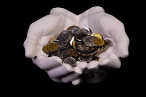 hands holding coins selective and soft focus isolated on black background with copy space. photo