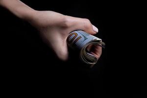 two hands with dollars. Closeup female hand giving money for something with isolated on black background,count, paying, shopping with dollar, corruption, counting dollar banknotes on black photo