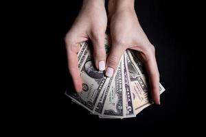 two hands with dollars. Closeup female hand giving money for something with isolated on black background,count, paying, shopping with dollar, corruption, counting dollar banknotes on black photo