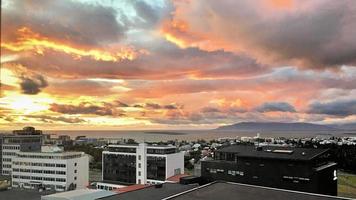 una puesta de sol sobre reykjavik en islandia foto