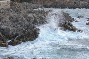 Sea reaching the rocks creating splashes of foam photo