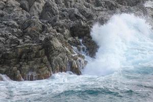 Sea reaching the rocks creating splashes of foam photo