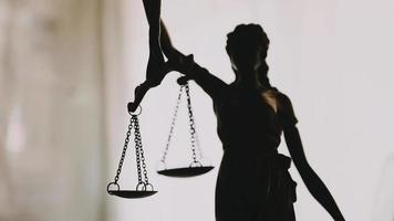 Justice and law concept.Male judge in a courtroom with the gavel, working with, computer and docking keyboard, eyeglasses, on table in morning light video