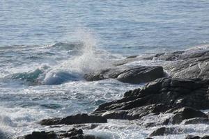 Sea reaching the rocks creating splashes of foam photo