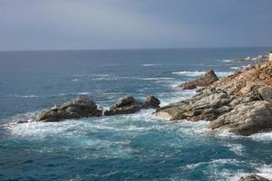 mar llegando a las rocas creando salpicaduras de espuma foto