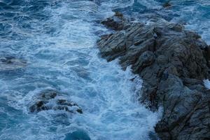 Sea reaching the rocks creating splashes of foam photo