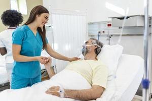 Healthcare concept of professional doctor consulting and comforting elderly patient in hospital bed or counsel diagnosis health. Medical doctor or nurse holding senior patient's hands photo
