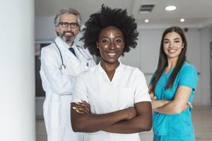 Smiling medical team standing togetherin a hospital, profession, people and medicine concept - group of happy doctors at hospital photo