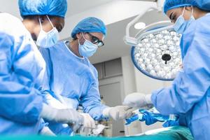 cirujanos que realizan operaciones en el quirófano. cirugía de aumento de senos en el implante de herramientas de cirujano de quirófano. concepto de atención médica. foto