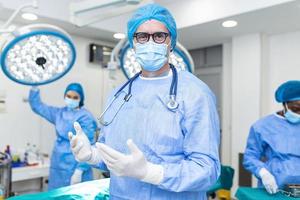 Portrait of male surgeon wearing surgical mask in operation theater at hospital. Healthcare workers in the Coronavirus Covid19 pandemic photo