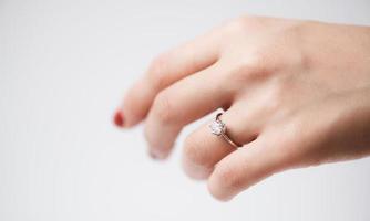 Close up of an elegant engagement diamond ring on woman finger photo