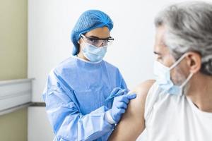 Female doctor or nurse giving shot or vaccine to a patient's shoulder. Vaccination and prevention against flu or virus pandemic. vaccination concept photo