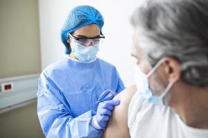 médico que usa traje de ppe y máscara quirúrgica y usa la vacuna con un paciente infectado en la sala de cuarentena brote de coronavirus covid-19 o covid-19, concepto de cuarentena covid-19