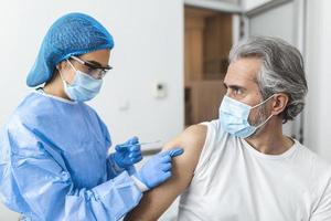 médico que usa traje de ppe y máscara quirúrgica y usa la vacuna con un paciente infectado en la sala de cuarentena brote de coronavirus covid-19 o covid-19, concepto de cuarentena covid-19