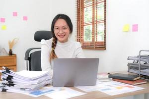 Cheerful lady working on laptop in home and use a computer laptop and thinking idea for her business photo