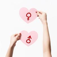 Close up women holding pink paper with heart shape on white background. photo