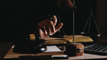 företag och advokater diskuterar kontraktshandlingar med mässingsvåg på skrivbordet på kontoret. juridik, juridiska tjänster, rådgivning, rättvisa och juridik konceptbild med filmkornseffekt video