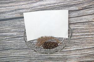 A5 paper greeting card mockup with dry leaves on wooden background photo