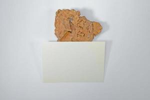 A5 paper greeting card mockup with grunge stone on white background photo
