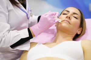 médico pintando el área de la cara de una mujer donde se inyectarán los hilos de tratamiento de sutura pdo. foto