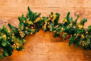 Christmas fir tree with lights on wooden background with copy space photo