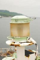 Marine signal light and emergency signal lamp off during the day, against the backdrop of the sea and sky photo