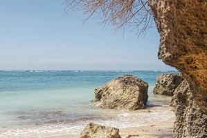 Tropical beach with panoramic views and waves, rocks and sand background photo