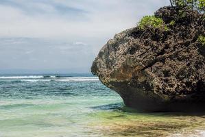 Tropical beach with panoramic views and waves, rocks and sand background photo