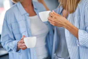 Nice two adult girls in the kitchen with coffee photo