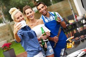 Group of friends having barbecue party and taking selfie photo
