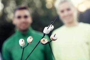 grupo de amigos preparando malvaviscos en una fogata foto